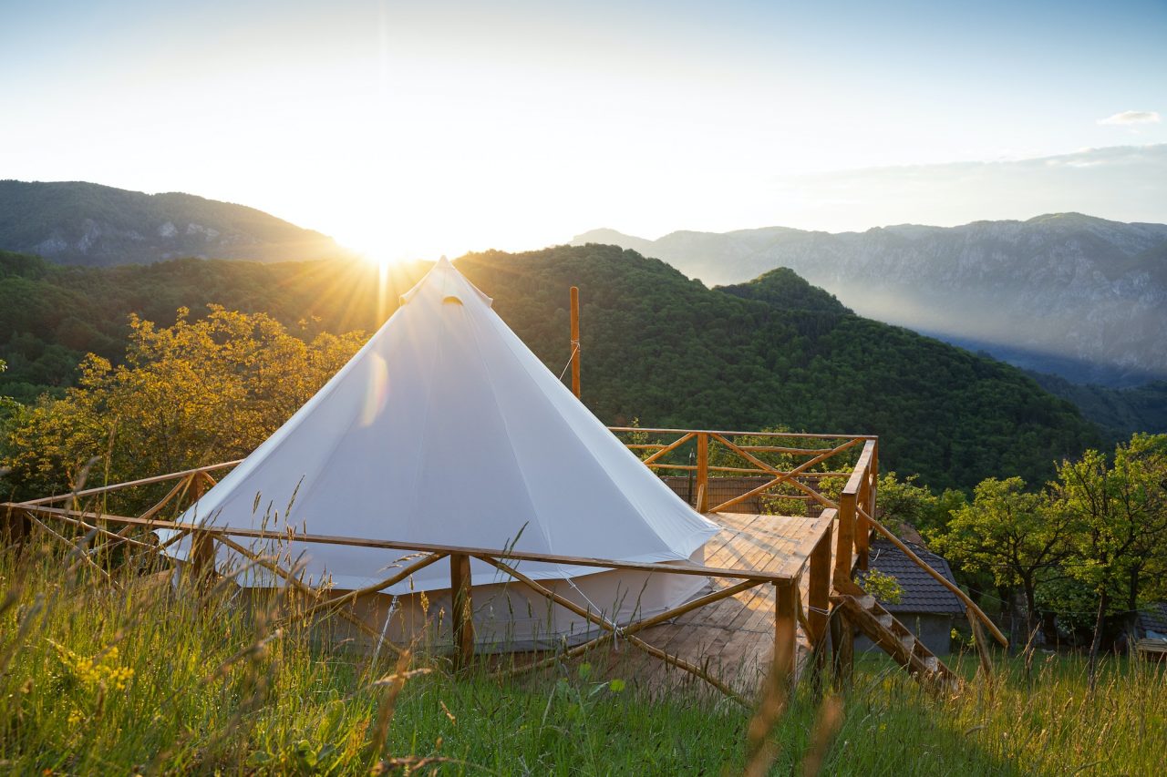 Glamping Tent In The Morning Sunlight With Mountain Range Panorama.jpg